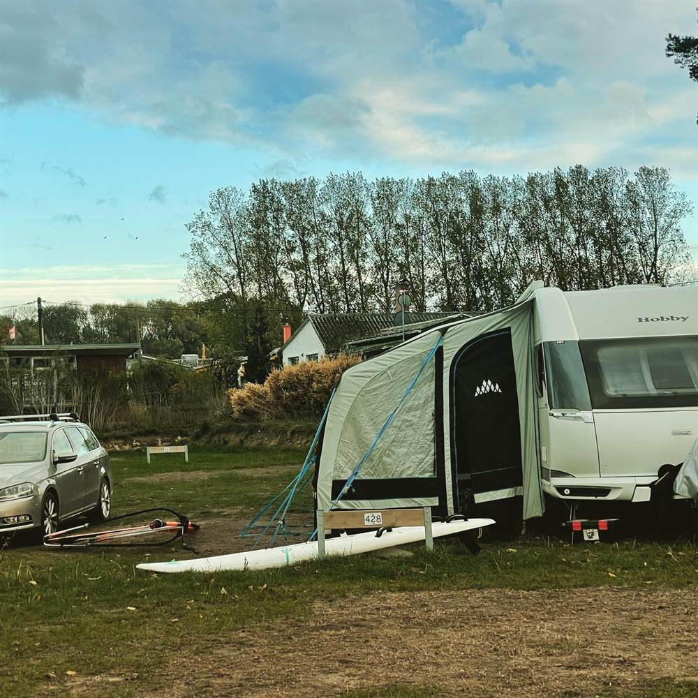 Hobby Wohnwagen mit Luftvorzelt und blauen Abspannleinen auf dem Campingplatz – so sieht ein gut gesichertes Luftvorzelt aus
