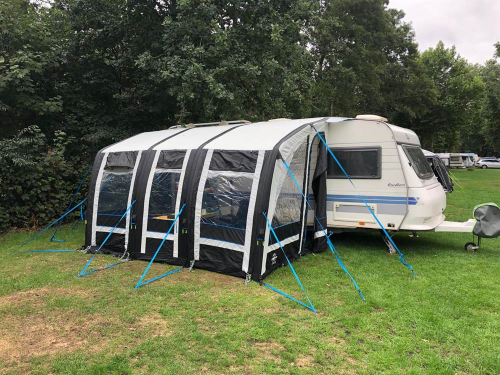 Großes Luftvorzelt am Wohnwagen mit vielen blauen Abspannleinen – gut gesichertes Vollvorzelt auf Campingplatz